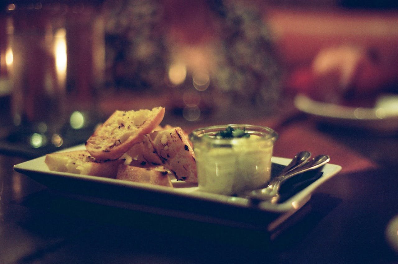 A cozy scene of bruschetta served with creamy dip in a restaurant setting.