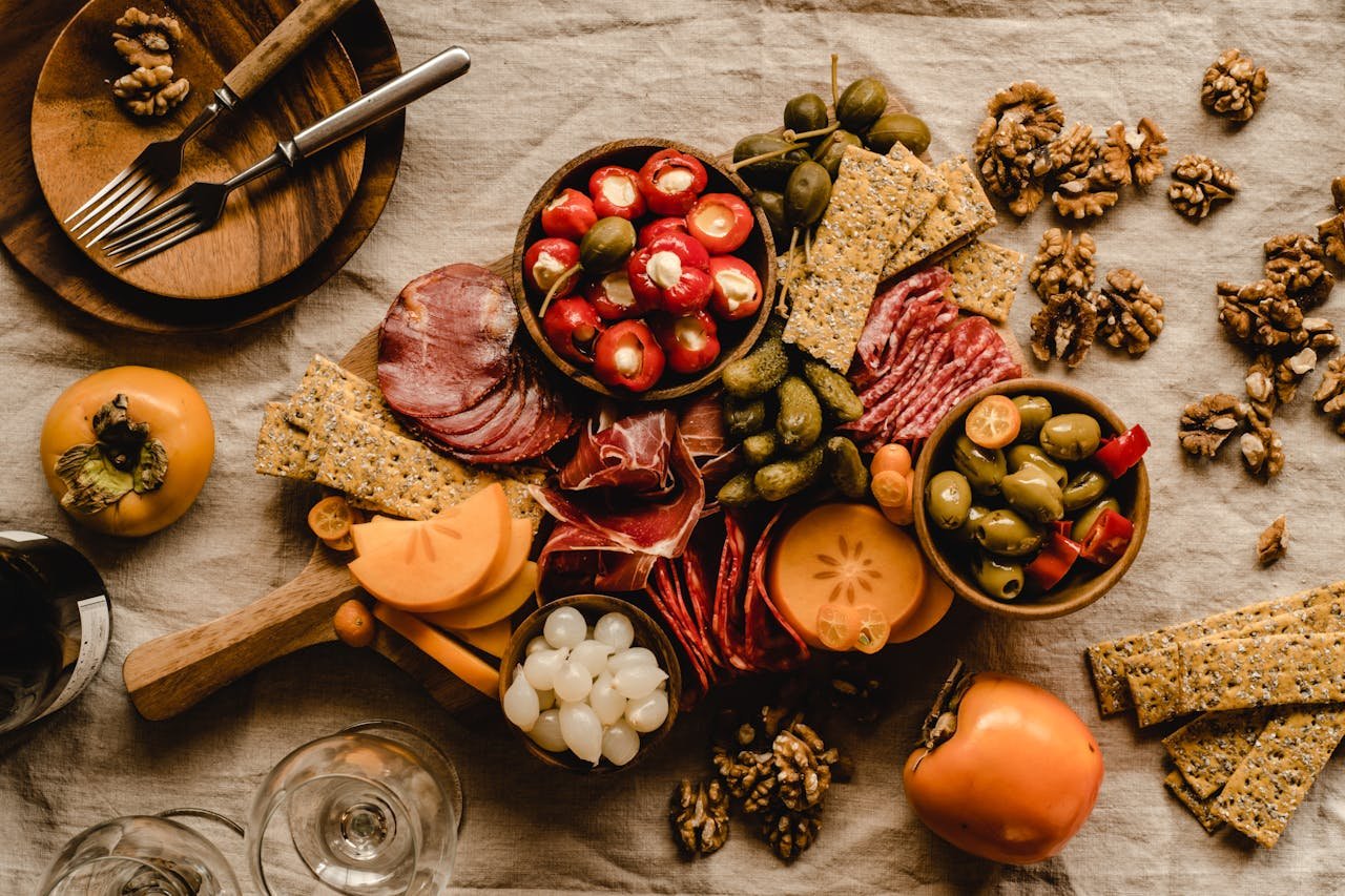 A beautifully arranged Mediterranean charcuterie board featuring meats, cheeses, olives, and nuts.